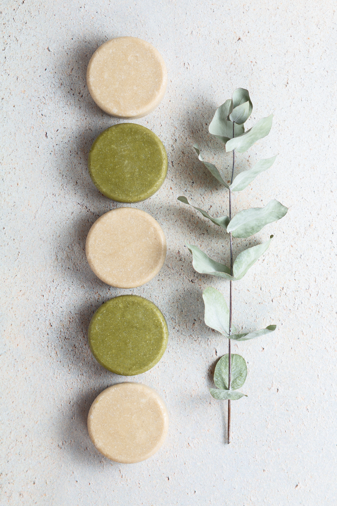 Eco friendly solid handmade colorful shampoo bars on light colored background.