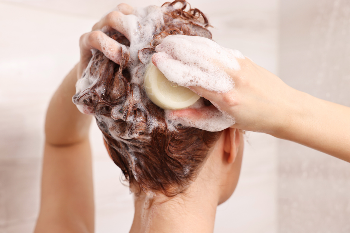 Young Woman Washing Her Hair with Solid Shampoo Bar in , B